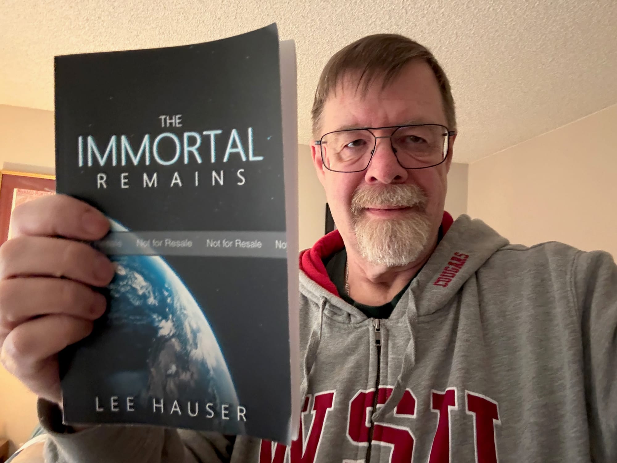 Author Lee Hauser, holding the proof copy of his book The Immortal Remains