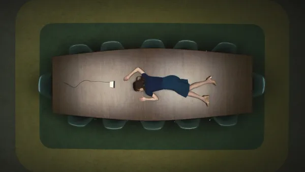 A woman in blue skirt and sweater lies, apparently asleep, on a conference room table. An intercom rests at her head. The chairs around the table a very neatly aligned and completely empty.